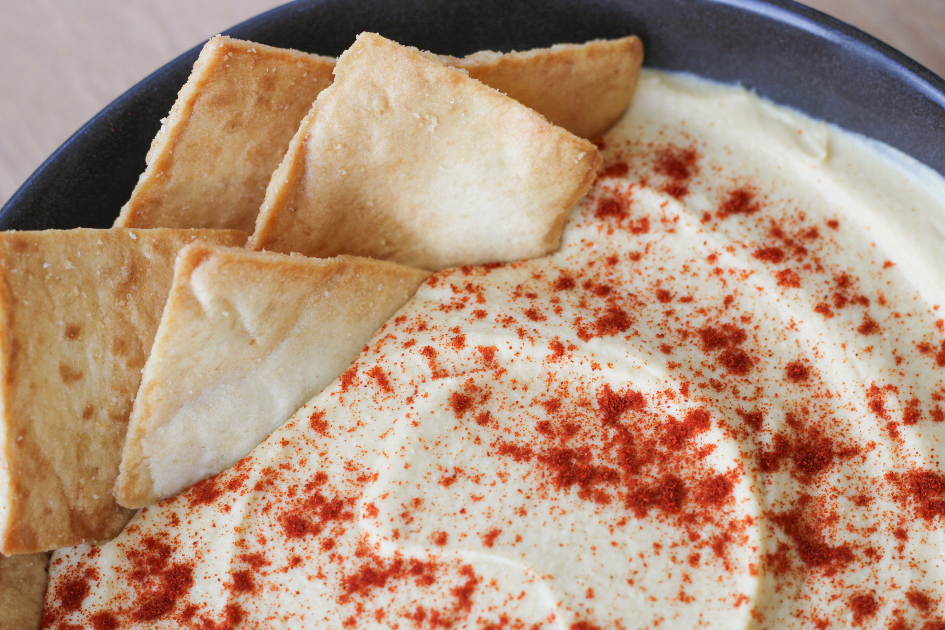 homemade hummus with pita chips and paprika